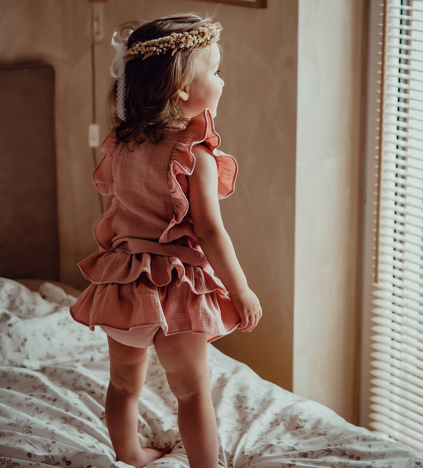 Mädchen trägt Baby Bloomer und Top mit Rüschen in rosa aus Bio-Musselin von Dear Eco