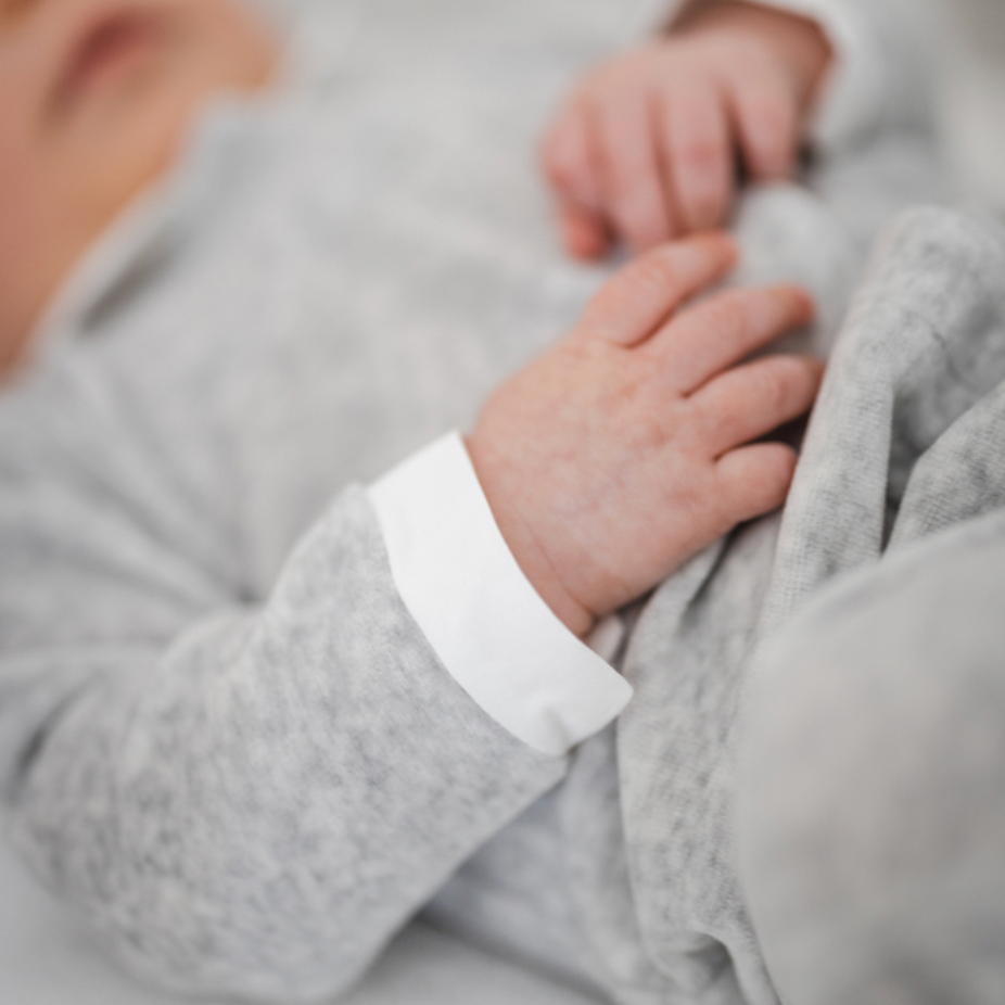 Baby im Strampler aus Samt in Hellgrau