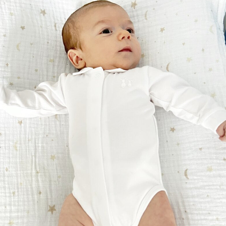Baby liegt auf einem Pucktuch mit Mond & Sternen von Poetree Kids