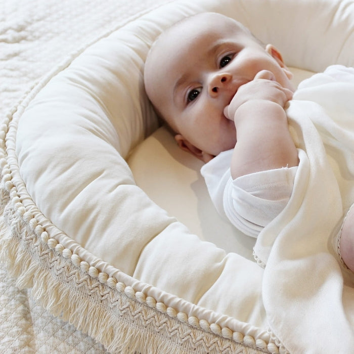 Baby liegt im Babynest Boho vanille