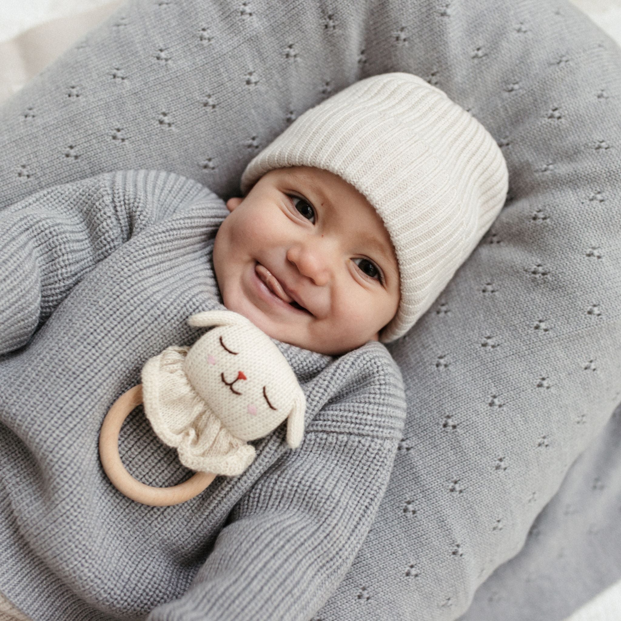 Baby angezogen in ein Pullover aus Merinowolle grau