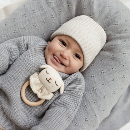 Baby angezogen in ein Pullover aus Merinowolle grau
